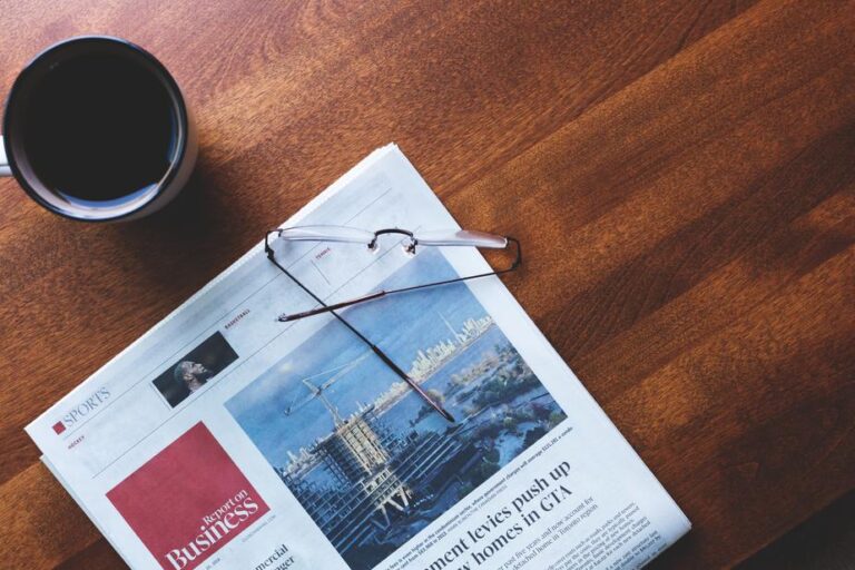 glasses sitting on newspaper on table next to coffee cup