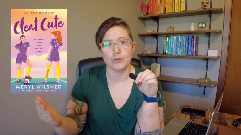 a photo of annie on front of a bookshelf gesturing to a screenshot of the cover of Cleat Cute.